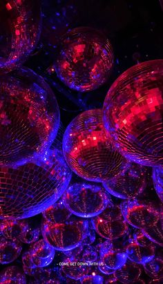 many disco balls are lit up in purple and red colors, with the lights turned on