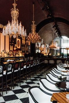 an elegant restaurant with chandeliers and black and white checkered flooring