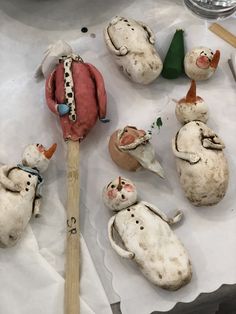 several clay animals are sitting on paper and next to a pair of chopsticks