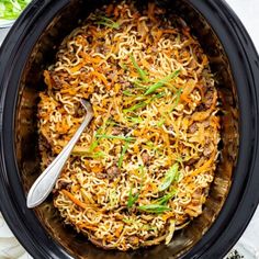 a slow cooker filled with noodles and meat