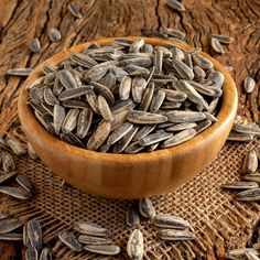 a wooden bowl filled with sunflower seeds