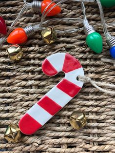 a red and white candy cane ornament on a wicker basket with christmas lights