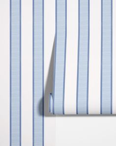 the blue and white striped wallpaper is next to an empty piece of paper that has been placed on top of it