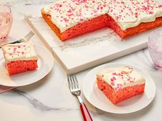 two slices of red velvet cake with white frosting and pink sprinkles