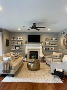 a living room filled with furniture and a flat screen tv mounted on the wall above a fire place