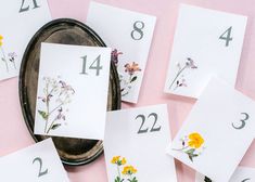 some cards with flowers on them sitting next to each other and numbers in the background