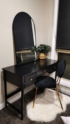 a desk with a mirror, chair and potted plant on it in front of a window