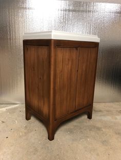 a wooden cabinet sitting on top of a cement floor