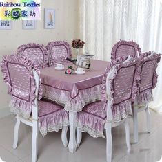 a dining room table and chairs covered in purple ruffled cloths with white trim