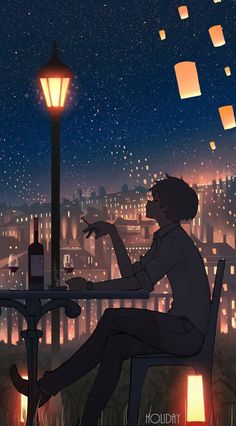 a man sitting at a table in front of a lamp post with paper lanterns floating above