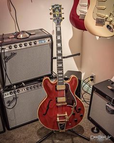 an electric guitar sits in front of two amps