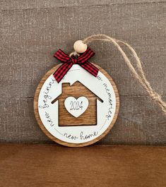 a wooden ornament with a house on it and a heart in the center