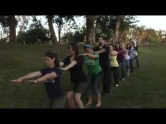 a group of people standing on top of a lush green field holding frisbees