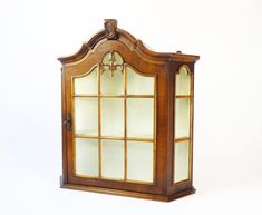 an old wooden display case with glass doors on the top and bottom shelves, in front of a white background