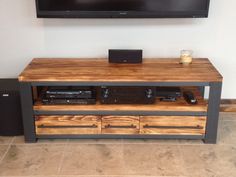 a flat screen tv mounted on top of a wooden entertainment center