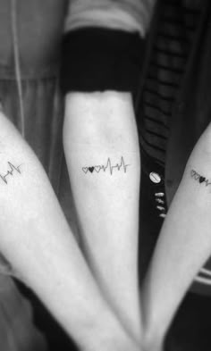 three people with matching tattoos on their arms