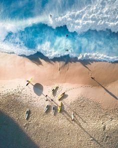 an aerial view of the beach with surfboards and kayaks