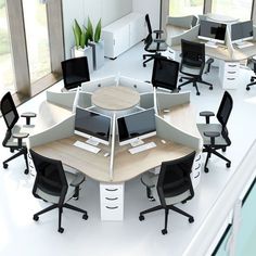 an office cubicle with multiple computer screens and chairs