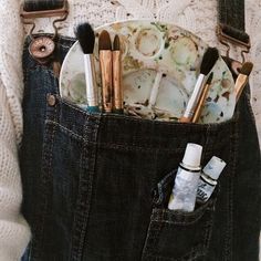 a person holding a pocket full of makeup brushes and toothbrushes in their pockets