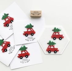 four red cars with christmas trees on them are next to a rubber stamp and some white paper