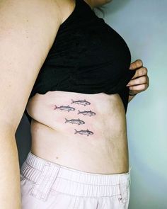 a woman's stomach with three fish on it and the bottom part of her belly