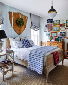 a bedroom decorated in blue and white with pictures hanging on the wall above the bed