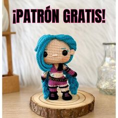 a small crocheted doll sitting on top of a wooden stump with the caption patron grats