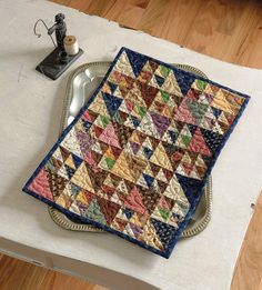 a table with a quilt on top of it and a sewing machine next to it