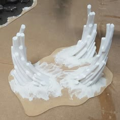 some white sculptures sitting on top of a brown table next to black and white paint