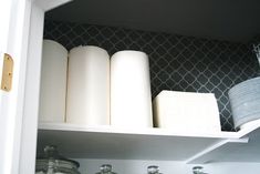 the shelves are organized with jars and paper towels