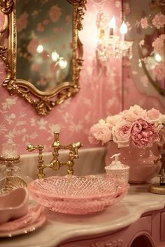 a bathroom with pink flowers and gold accents on the vanity, mirror and sink area