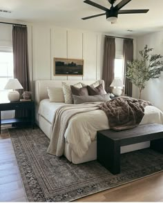 a bedroom with a large bed sitting on top of a rug next to a window