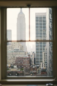 the view from an apartment window in new york city, looking out at skyscrapers