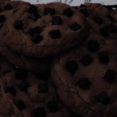 a pile of chocolate chip cookies sitting next to each other on top of a table