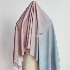 a pink and blue shawl draped over a mannequin head