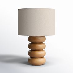 a lamp made out of wood stacked on top of each other with a white shade