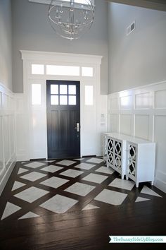 an empty room with a black and white checkerboard pattern on the floor in front of a door