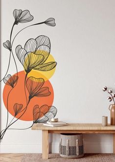 an orange and yellow flower wall decal on a white wall next to a wooden table