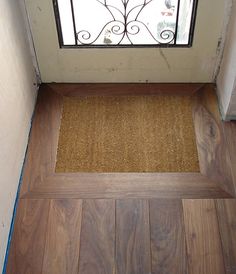 the door mat is on the floor in front of the window with an iron frame