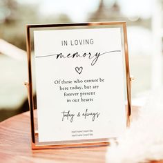 a sign that says in loving memory on it sitting on top of a wooden table