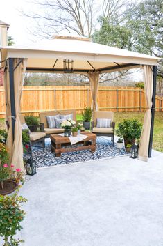 an outdoor living area with couches, tables and a gazebo