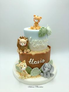 a three tiered cake with jungle animals on top