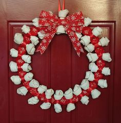 a christmas wreath made out of marshmallows on a red door