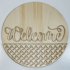 a wooden sign with the word welcome in cursive writing on it's side