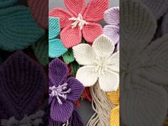 several different colored knitted flowers on display