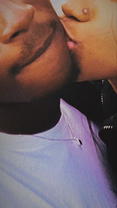 a close up of a person kissing another person