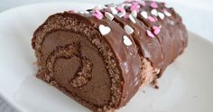 a chocolate roll with sprinkles on a white plate