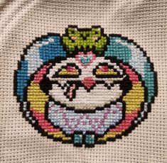 the cross stitch pattern has an image of a smiling cat on it's face