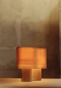 a lamp sitting on top of a table next to a wall