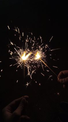 two people holding sparklers in their hands